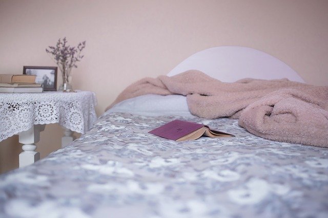 książka i koc na łóżku